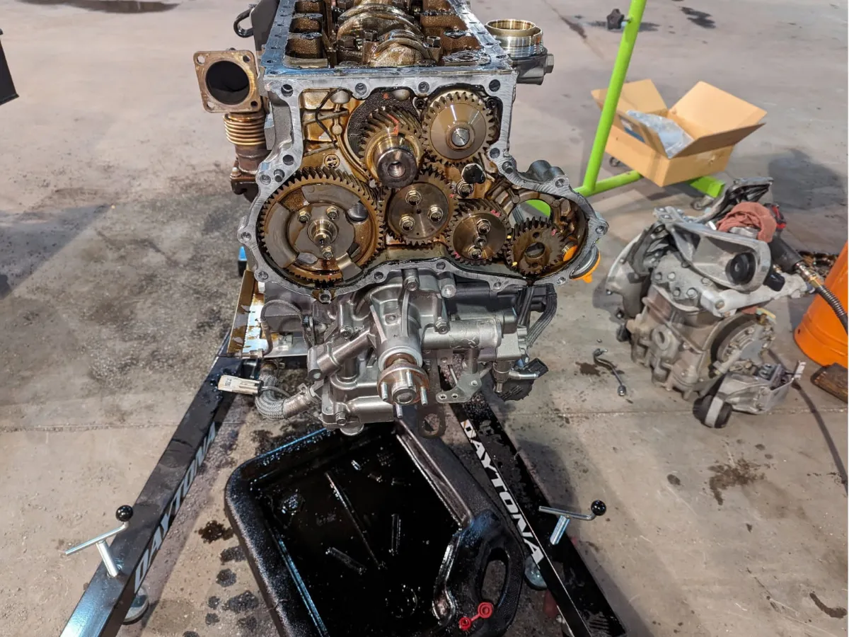 Diesel engine on a stand with the front cover removed and the timing gears exposed during a rebuild